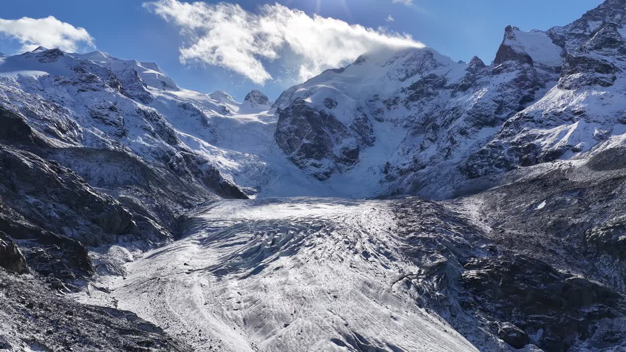 Vasto glaciar helado de Morteratsch descendiendo entre montañas alpinas cubiertas de nieve en Graubünden, Suiza