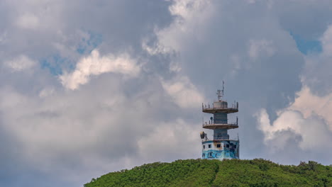 vecchia torre di telecomunicazioni su una collina vicino a noumea, nuova caledonia - lasso di tempo con cloudscape dinamico