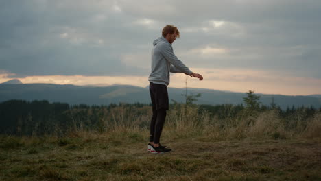 guy doing back flip on place in mountains. male sportsman performing somersault