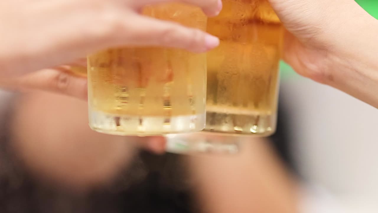Hands raising frosty glasses in a celebratory toast, capturing a moment of joy and connection.