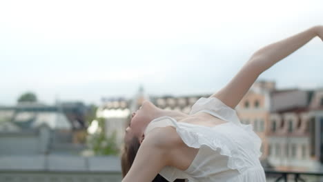 woman posing in artistic stretch on rooftop
