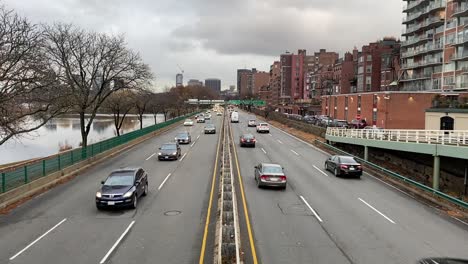 cars driving on 3 lane highway in light traffic in the city of boston massachusetts