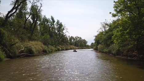 gente haciendo kayak en un río tranquilo y pacífico, explorando la naturaleza salvaje