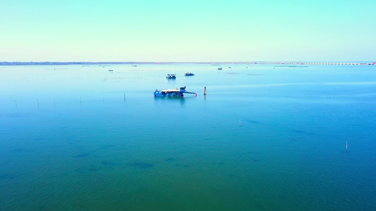 깨한 파란 물과 조개를 잡는 배가 있는 호수