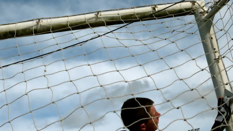 goalkeeper in red letting in a goal during a game