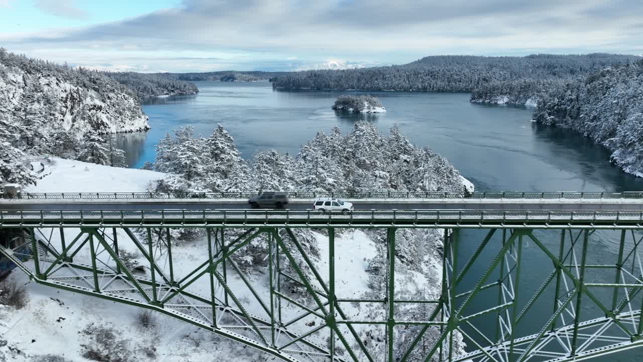 눈이 땅을 덮고 있는 동안 속임수 통과 다리를 가로질러 운전하는 흰색 suv