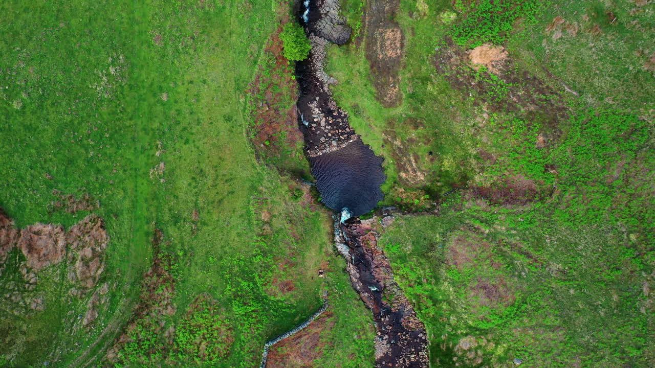 시골과 밝은 햇빛으로 둘러싸인 천연 암석 개울 위로 솟아오른 높은 공중 탑다운 전망