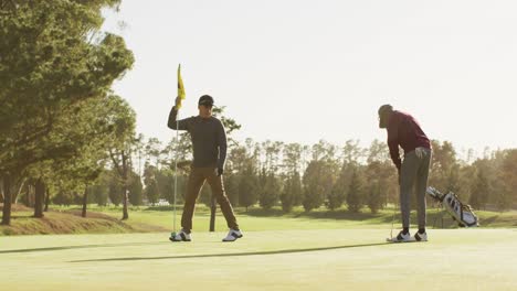 video de varios amigos varones jugando al golf en el campo de golf