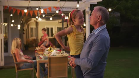 Grandfather-carrying-his-granddaughter-outdoors