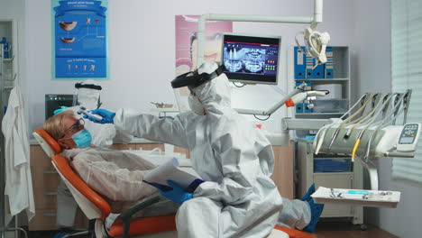 dentist nurse in potective suit controlling patient temperature