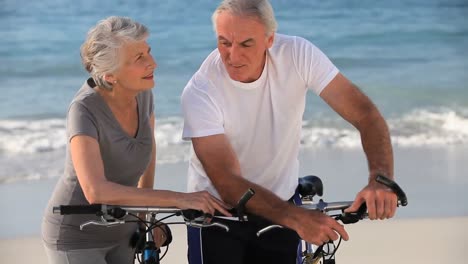 Pareja-De-Ancianos-Con-Bicicletas-Hablando-Entre-Sí