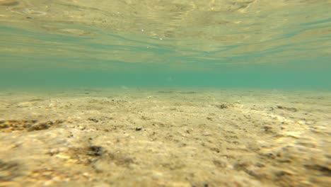 Footage-of-an-underwater-strong-current-in-a-shallow-waters-with-light-playing