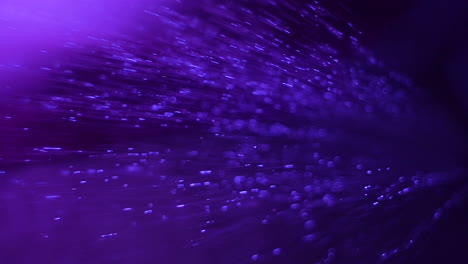 a close up of rain softly hitting the ground with a soothing purple background