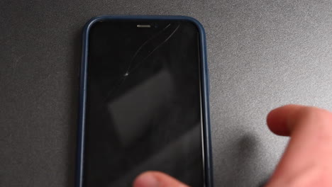 a phone user grabes his mobile on a grey desk to spend time on his screen