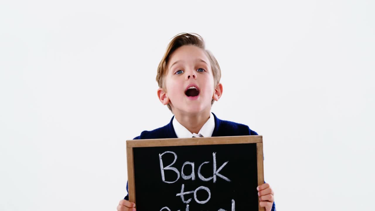 학교에 돌아가는 텍스트를 가진 칠판을 들고 있는 학교 소년