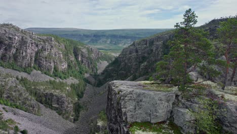 A-slow-moving-drone-passes-by-one-of-the-countless-cliffs-which-hang-over-the-Jutulhogget-in-Norway