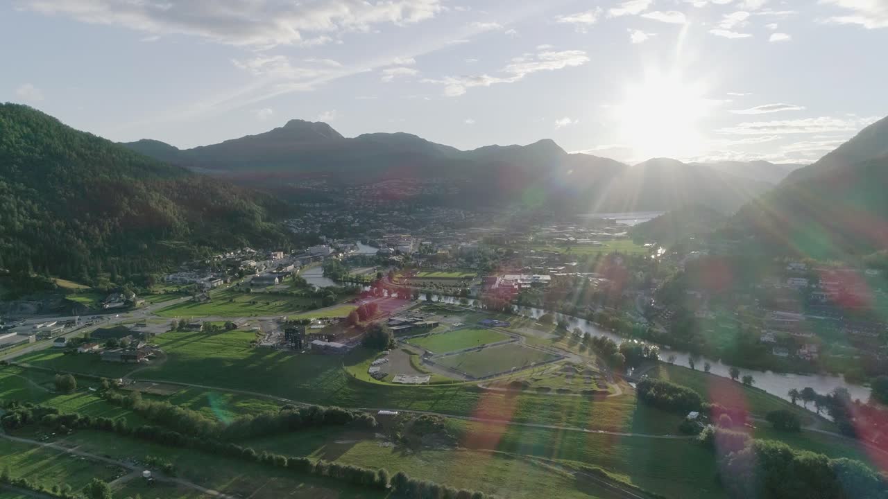 멋진 렌즈 플레어와 함께 일몰, 푸른 하늘 동안 노르웨이 마을의 공중 슬로모 와이드 샷