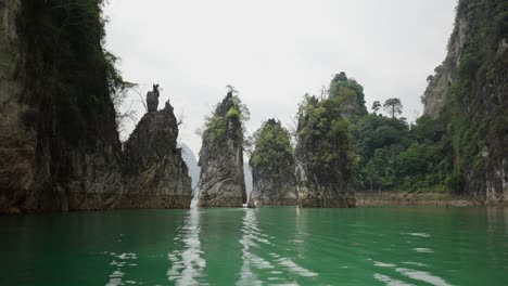 scenic boat ride through emerald lake with towering limestone karsts