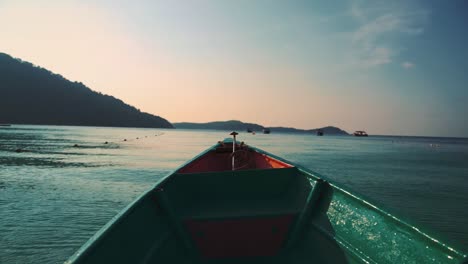 taking a boat ride at a tropical island in thailand by sunset in one of the famous, traditional and iconic thai longtail boats in slow motion
