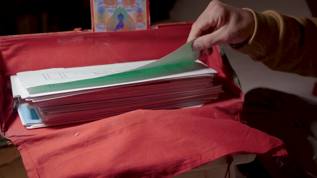 Ruka otevírající tradiční buddhistickou rituální knihu