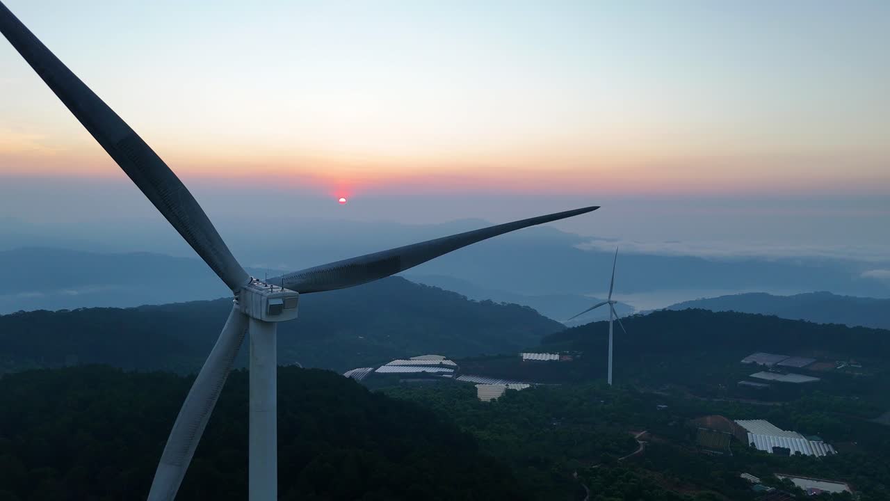 Wind turbine blades spin in the bright morning sunlight on the mountain | Vietnam