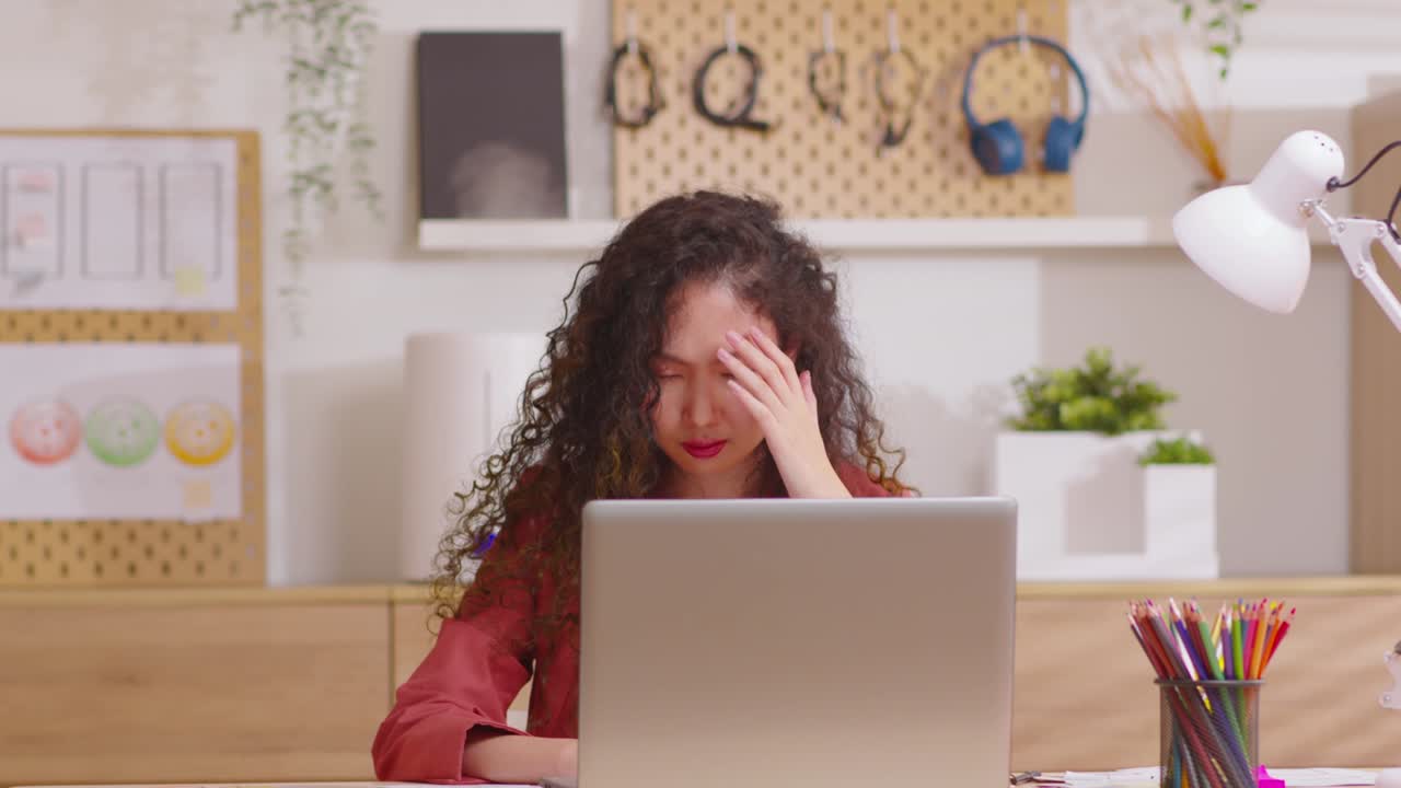 mujer asiática sentada en el escritorio frente a la computadora portátil estresado la cara y el dolor de cabeza muestra su estresado con el trabajo desde la oficina de casa. mujer pensando sobre el trabajo error o carga de trabajo tiene depresión.