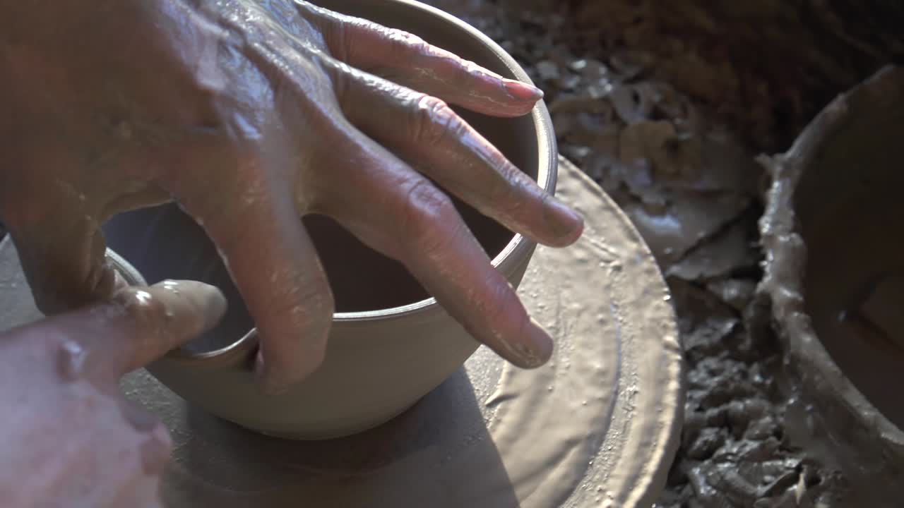 Potter's hands making a bowl