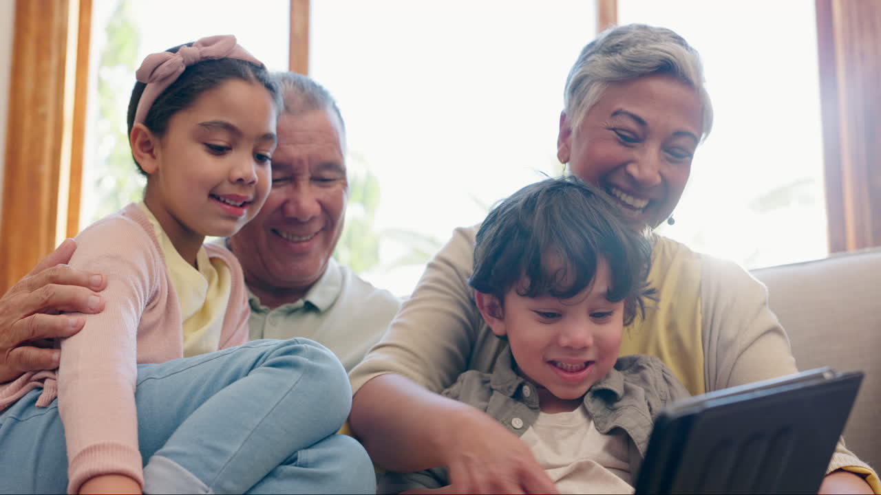 Tablet, grandparents and children on sofa