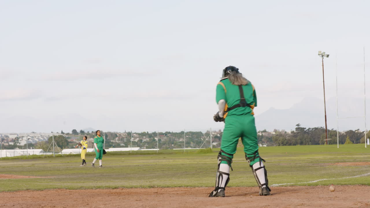 Multiracial female baseball players playing baseball, catching the ball on a pitch, copy space