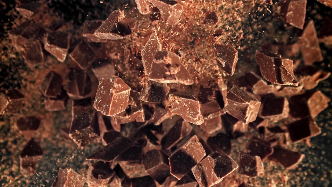 Chocolate Pieces and Cocoa Powder Falling in Slow Motion