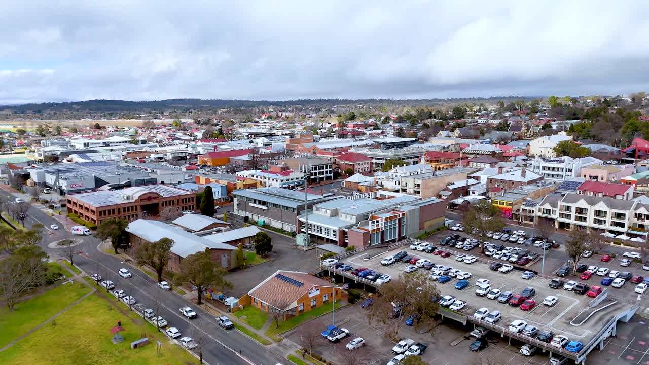 Drone footage shows buildings, streets, and parking in suburbia