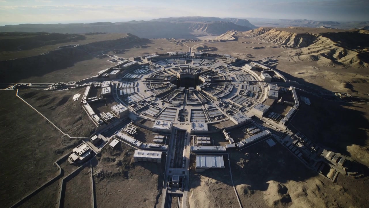 Starting flyover, drone descending to wheel compound over arid plain, surveying central void, rings