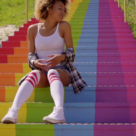 young woman sitting on the colorful stairs