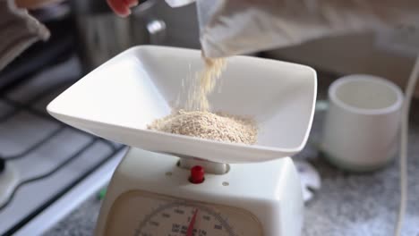 person pouring and weighing wheat germ powder on weighing scale