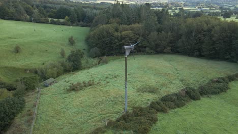 un molino de viento en la montaña wicklow utilizado para generar energía verde para encender una pequeña granja en irlanda - dron aéreo, tiro panorámico