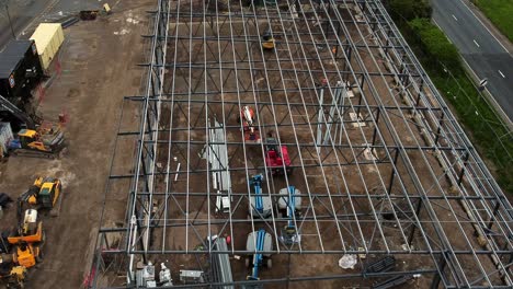 Vista-Aérea-Mirando-Hacia-Abajo-En-La-Tienda-De-Comestibles-Aldi-Sitio-De-Construcción-Estructura-De-Acero-De-Cimentación-Y-Equipo-De-Construcción