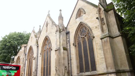 red bus passing historic church in oxford