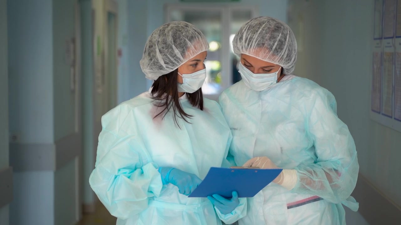 Dokter dan Perawat Wanita Mendiskusikan Diagnosis dan Perawatan Pasien