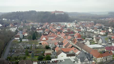 Vista-Aérea-De-Drones-Del-Tradicional-Pueblo-Alemán-Herzberg-Am-Harz-En-El-Famoso-Parque-Nacional-En-Alemania-Central-En-Un-Día-Nublado-En-Invierno.