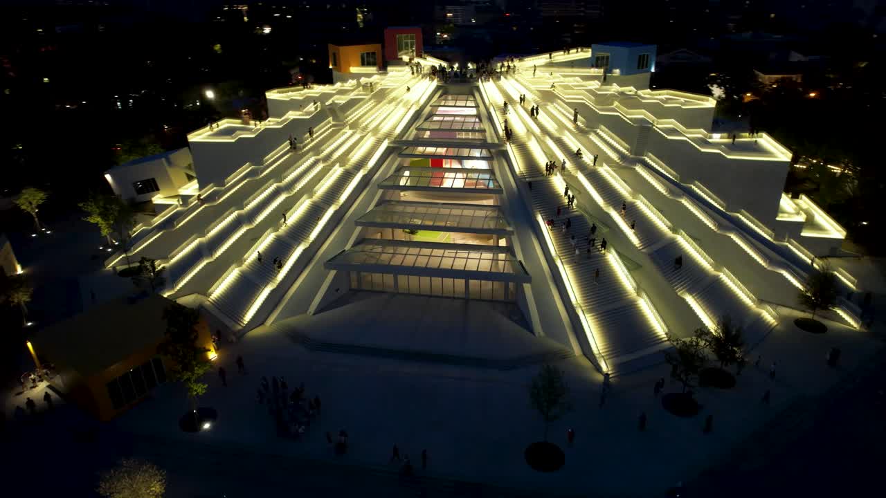 pirámide de albania con interminables escaleras iluminadas por la noche visitada por turistas y jóvenes en el centro de tirana