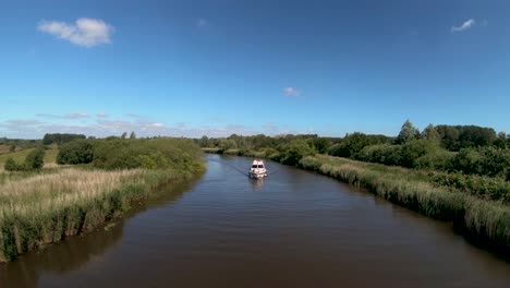 Aerial-Drone-Footage-of-a-boat-along-the-River-Waveney,-Norfolk