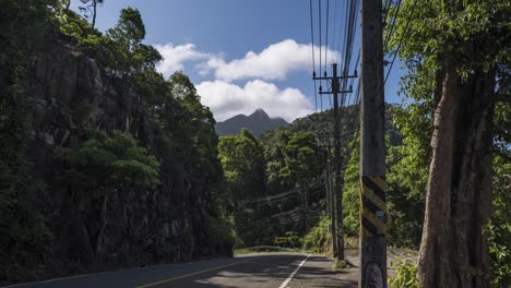 4k-zeitraffer-Am-Straßenrand-Von-Bergigem-Gelände-Auf-Der-Insel-Koh-Chang-In-Thailand-Mit-Strommasten-Am-Straßenrand-Mit-Fahrenden-Fahrzeugen