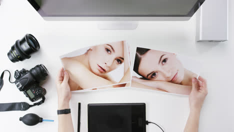 vista superior fotógrafo diseñador gráfico eligiendo imágenes de belleza trabajando en el escritorio desde arriba - dragón épico rojo