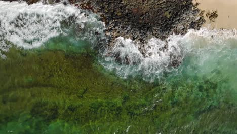 Wide-Aerial-Birds-Eye-view-moving-downwards-at-Shipwreck-Beach,-Hawaii