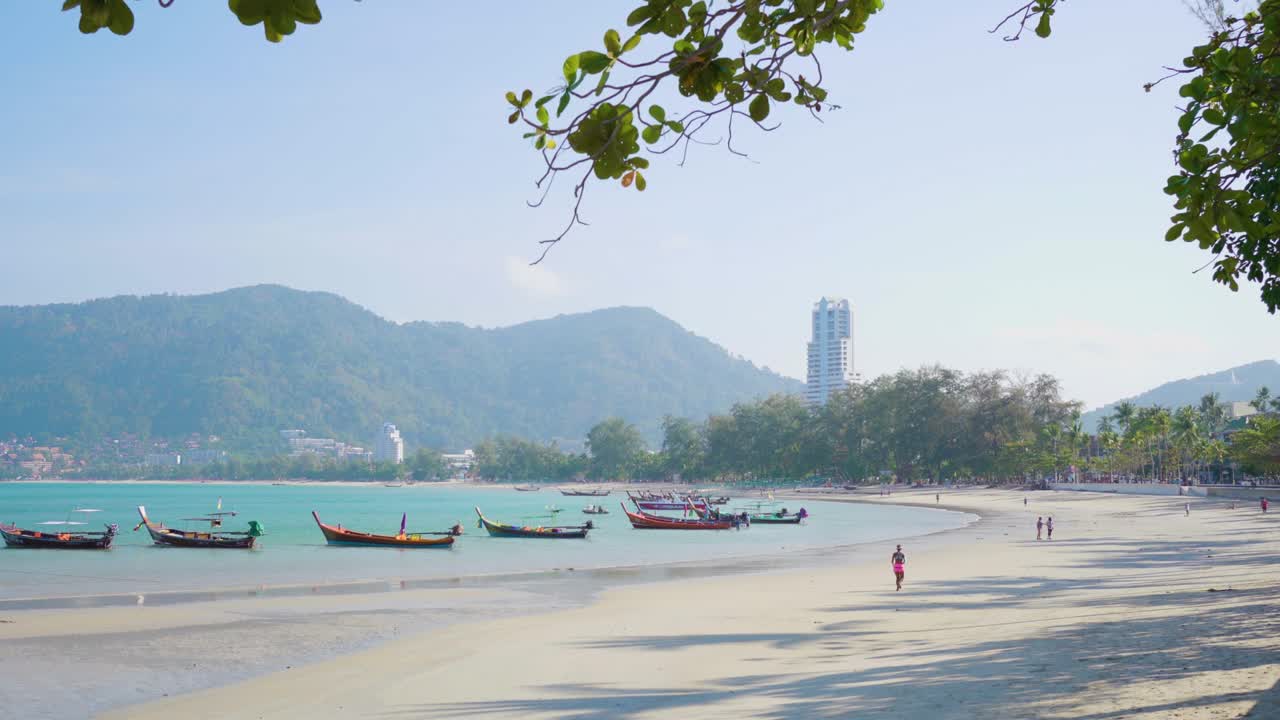 Fantastiske traditionelle longtail-turistbåde ligger til kaj ved den smukke Patong-strand i Phuket, Thailand.