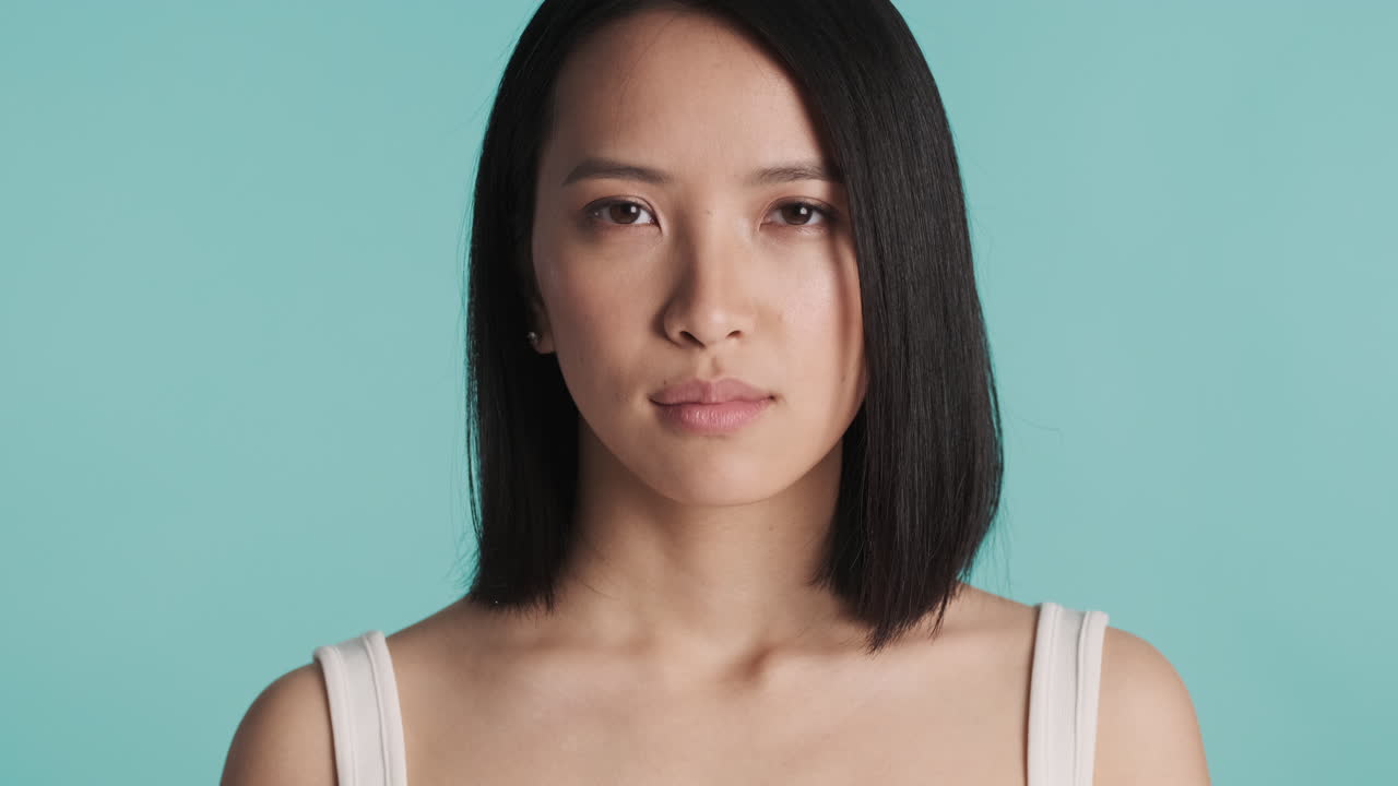 아시아 여성이 카메라 앞에서 깊은 숨을 쉬고 있습니다.