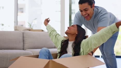 Moving-in,-box-and-a-homeowner-couple-playing