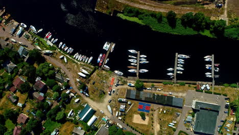 Boats-Docked-On-Riverside-With-Village-Houses-On-Banks