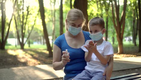 mom treats her son's hands with antiseptic