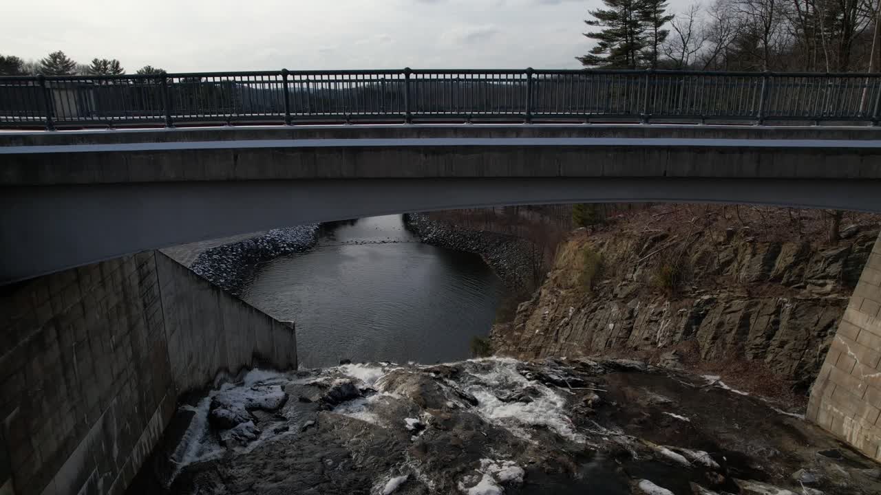 흐린 저녁에 저수지 유역을 향해 천천히 폭포 아래로 이동하는 낮은 고도의 드론 보기